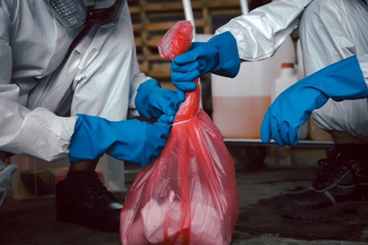 two people tying a bag together with a substance inside